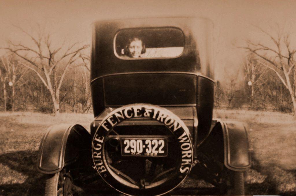 A view at an old picture of a car with a person sitting inside